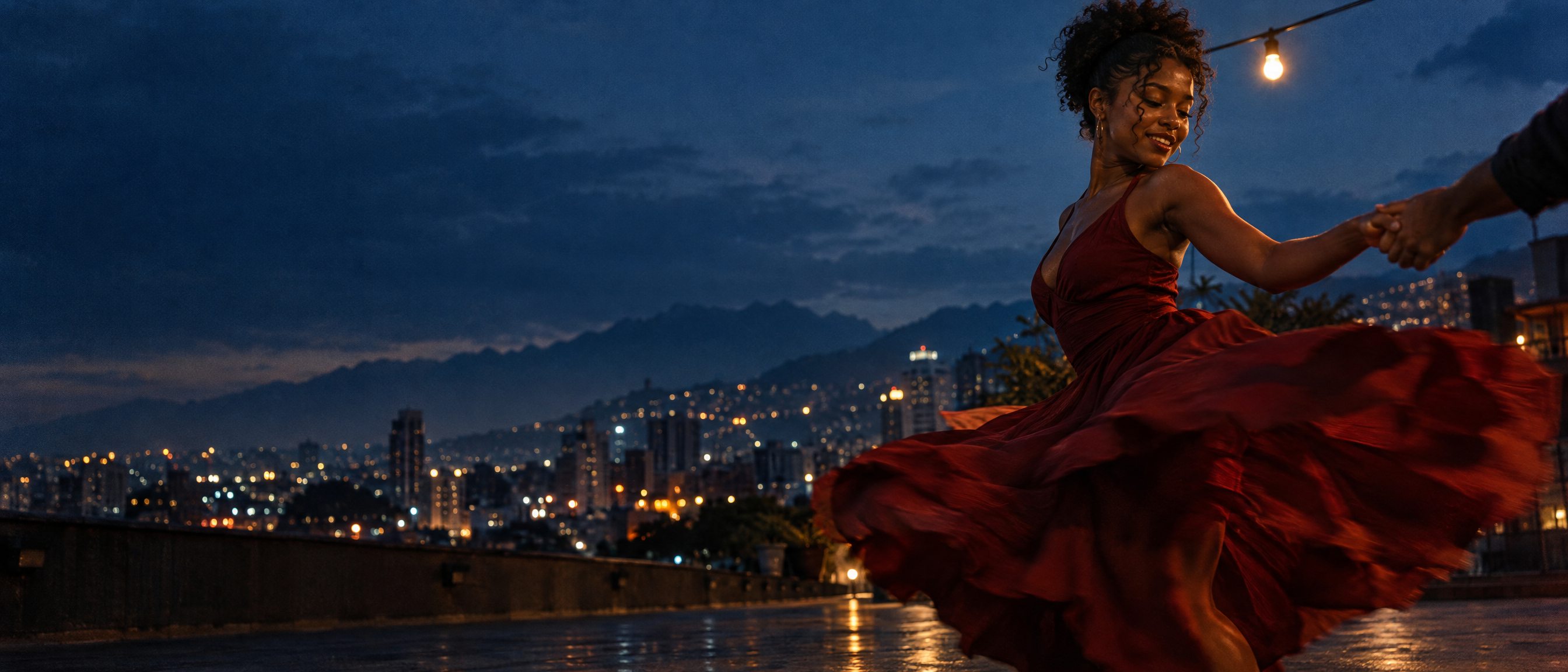 Plano de cine: bailarina de salsa girando en una terraza de Cali al anochecer, con luz de bombillo cálida y la ciudad detrás